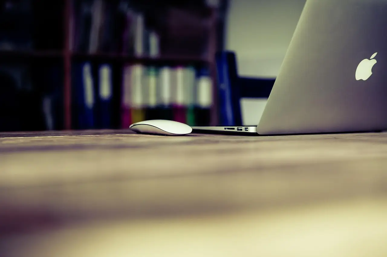 A laptop and mouse on a desk in a home office