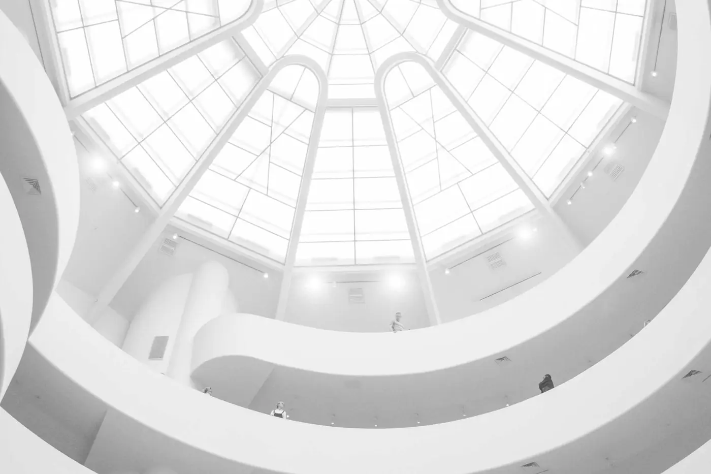 Circular atrium with a white spiral balcony and skylight