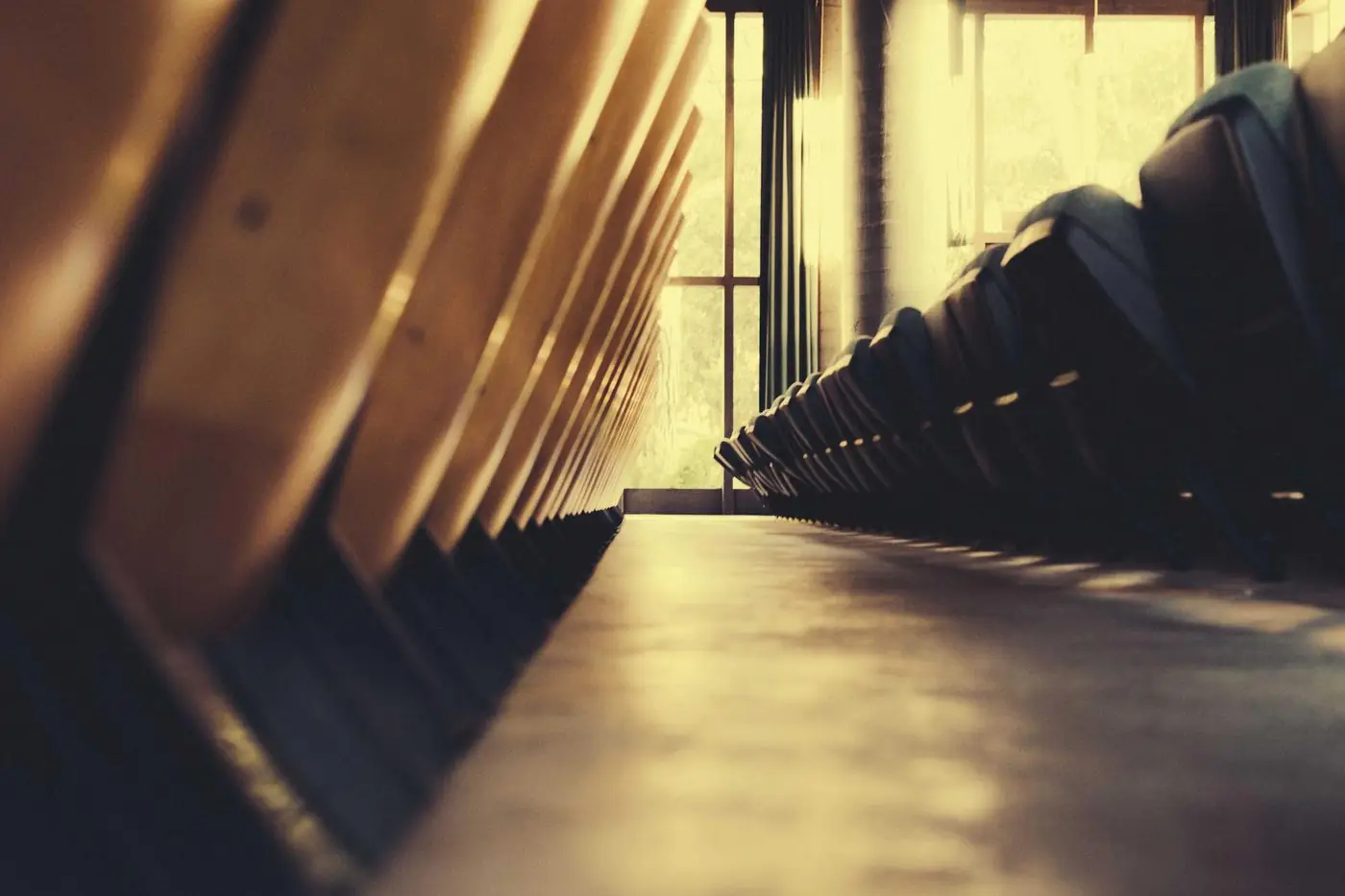 Wooden pews leading toward a bright window