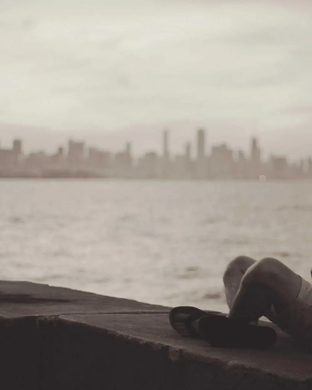 Person sitting by a window looking out over the water