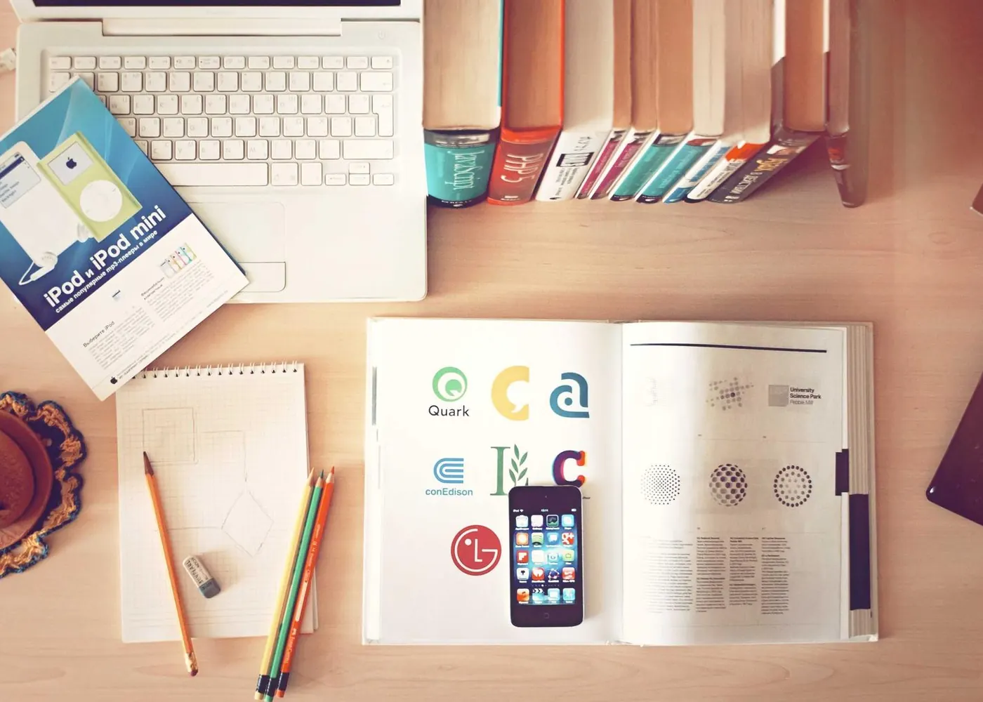 Designer's desk with a sketchbook, colour swatches and a laptop