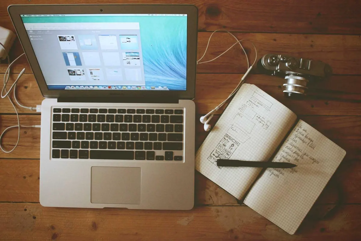 Laptop, notebook and coffee on a desk during a planning session