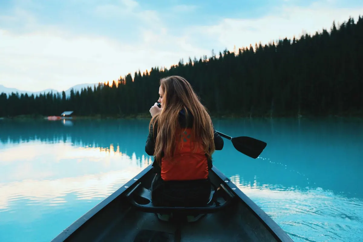 Traveller paddling a canoe across a misty lake