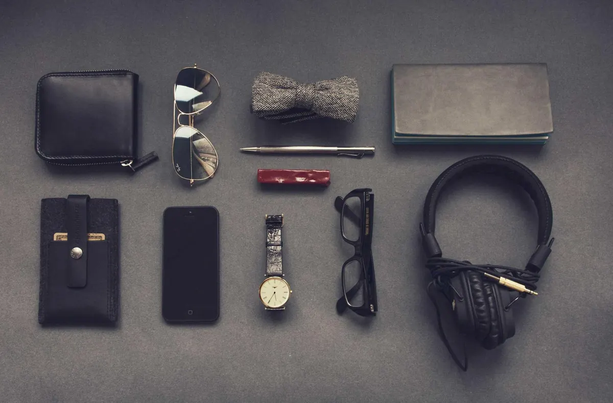 Flat lay of everyday carry items on a grey surface