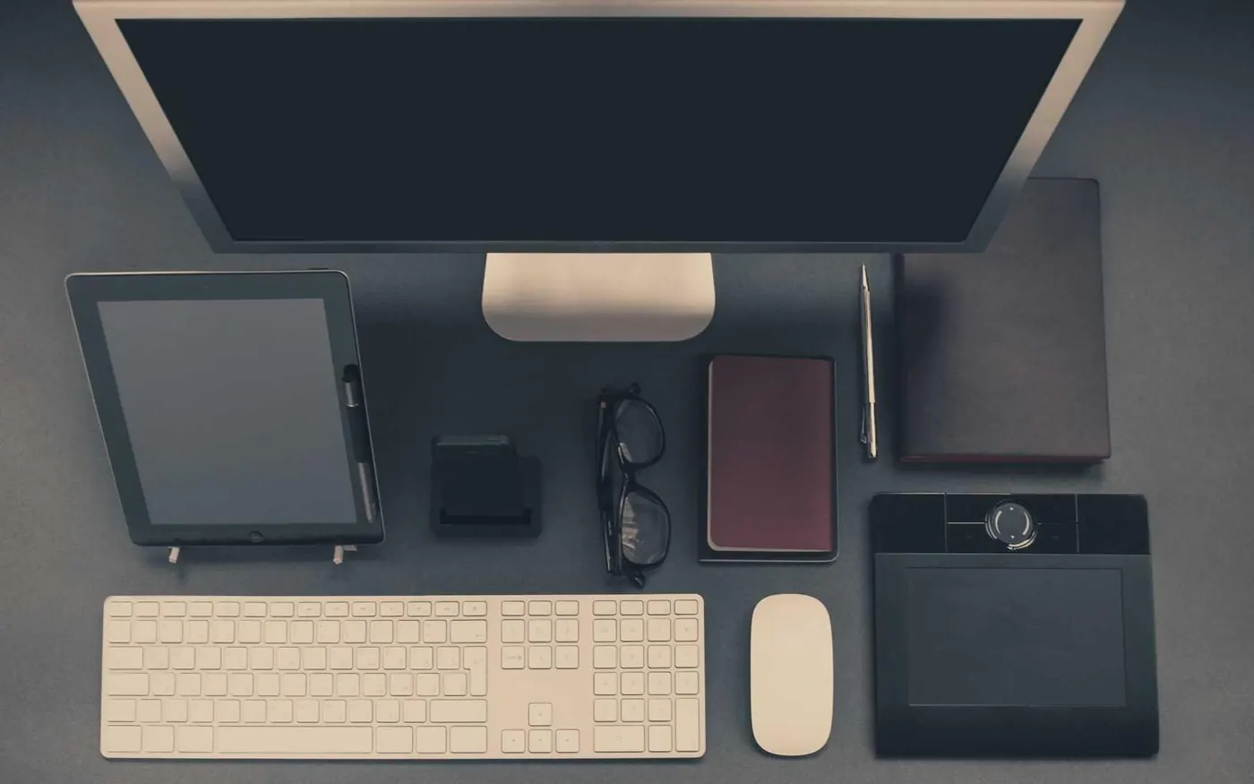 Tidy workspace with a monitor, keyboard and notebook