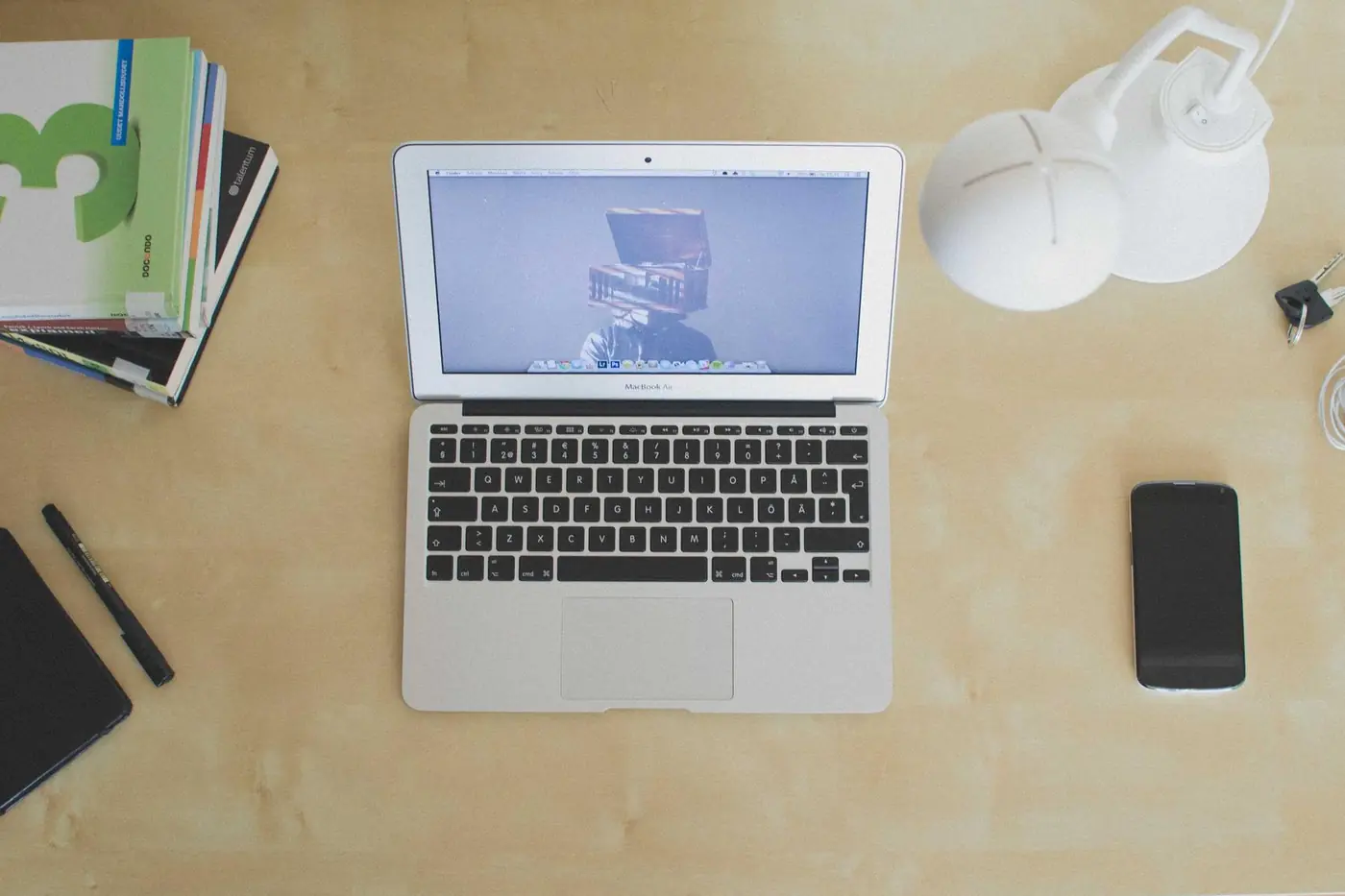 Laptop, notebook and coffee on a wooden table seen from above