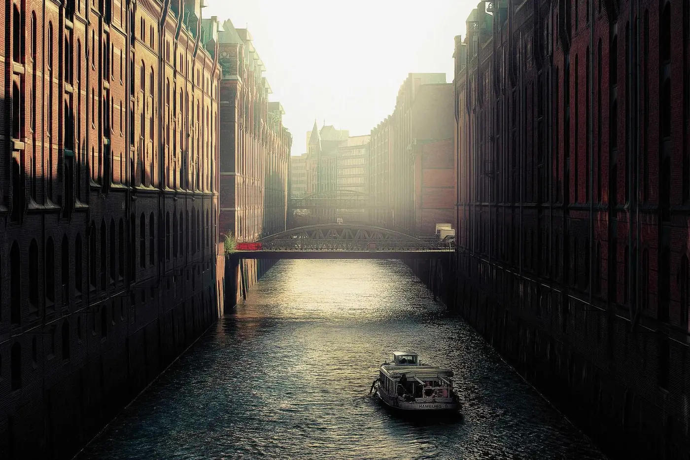 Misty canal street with a small boat