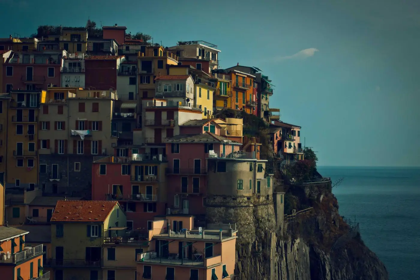 Colourful cliffside village above bright water