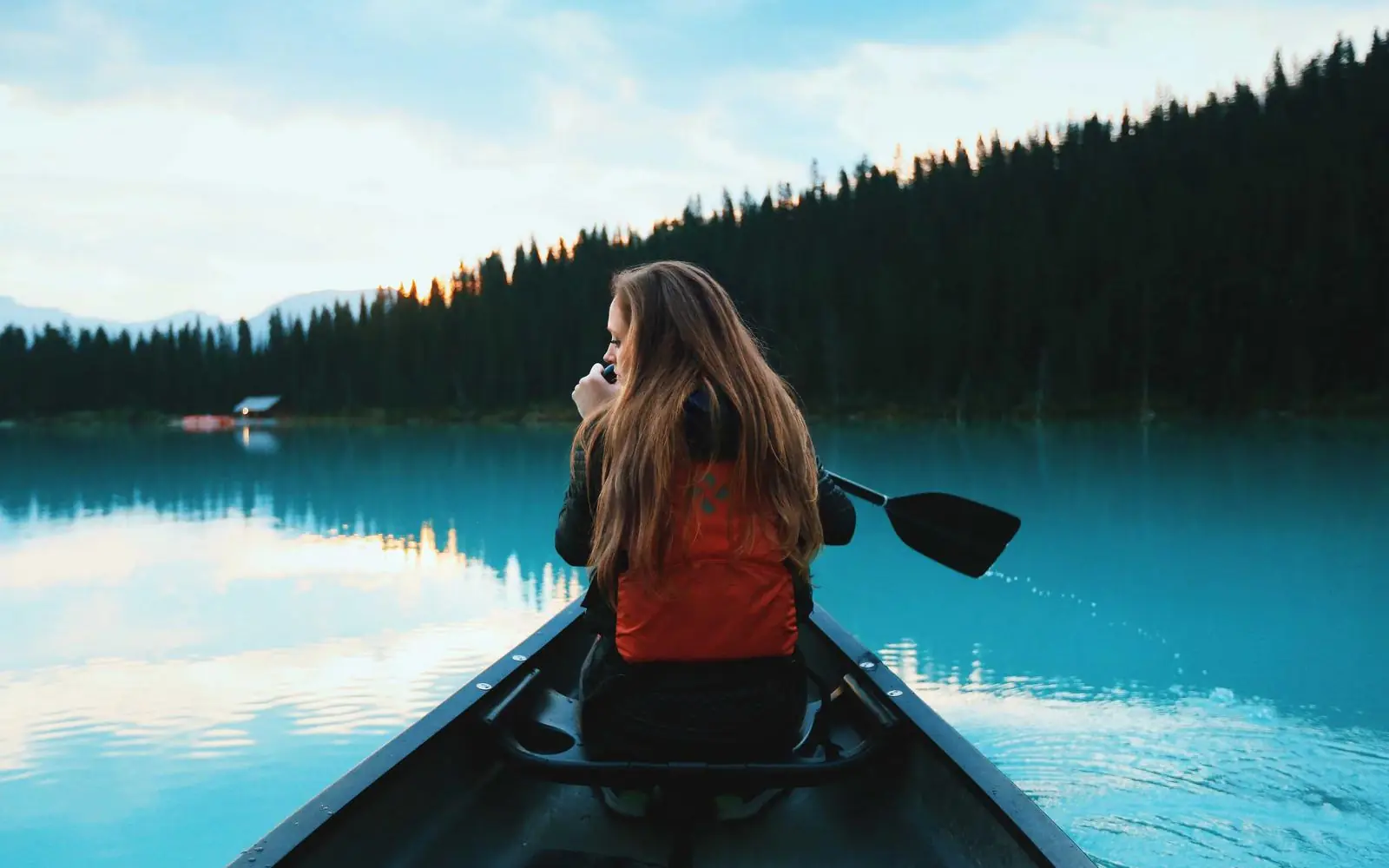 Traveller paddling a canoe across a misty lake